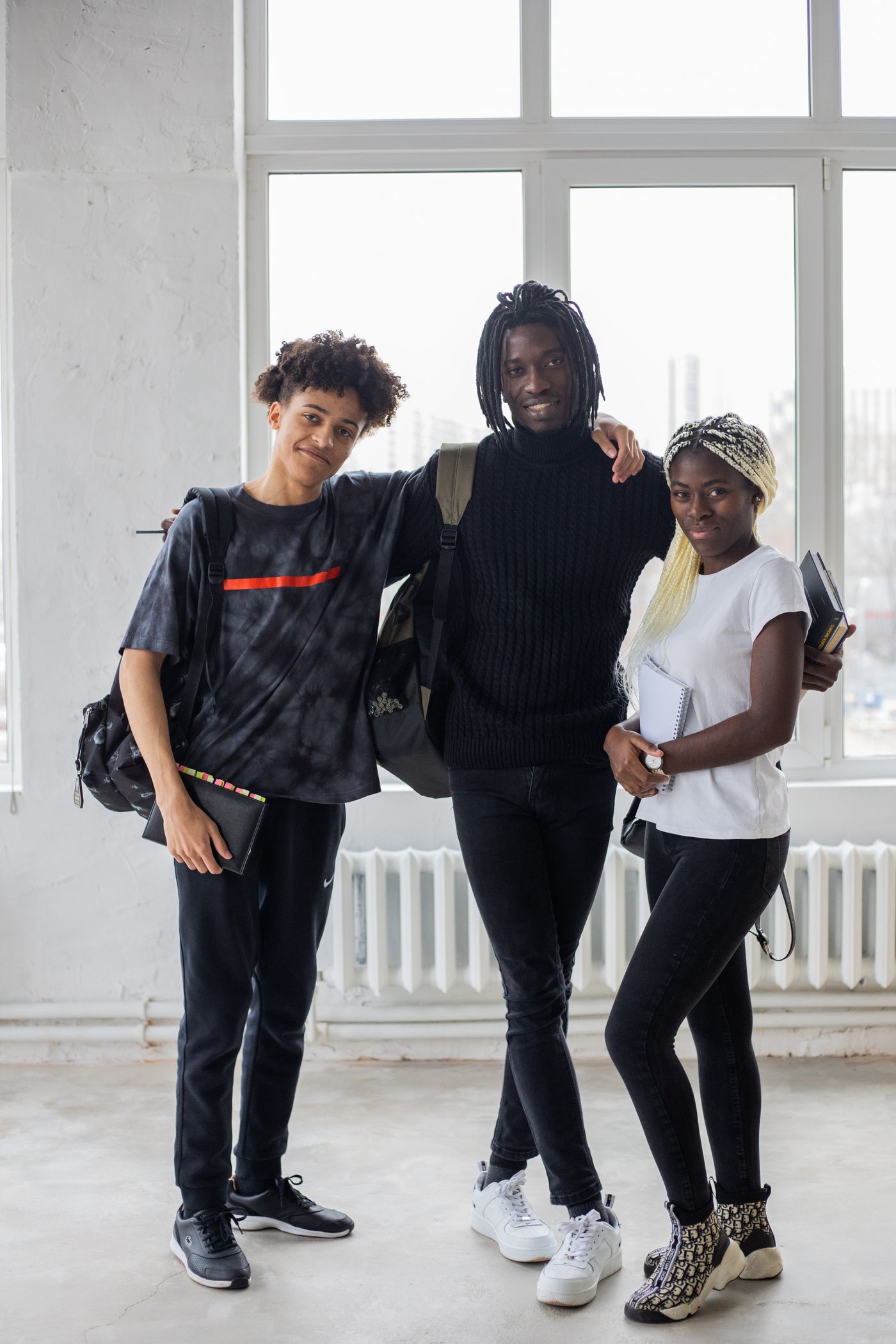 Black students smiling together with notebooks
